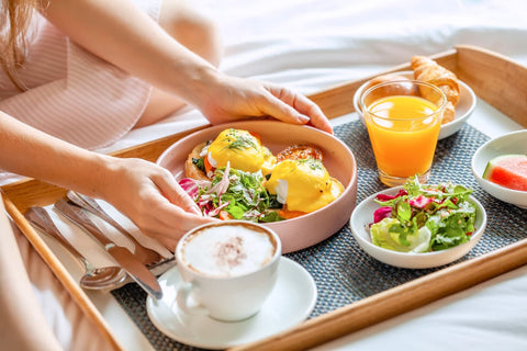 A balanced breakfast, including eggs benedict, salad, coffee, fruit and a glass of orange juice