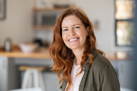 Middle aged woman with beautiful skin, smiling with her beautiful hair draped over her shoulder