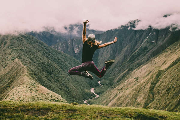 Women's Fitness, lady outdoors feeling energised, jumping amongst the green