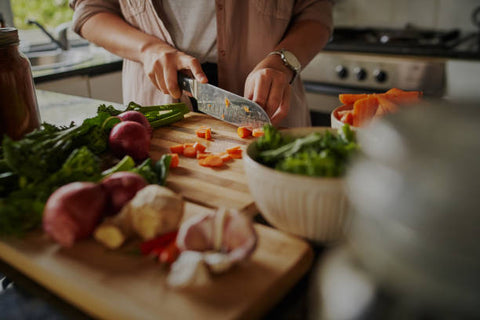 closeup of a young female chopping up vegatables