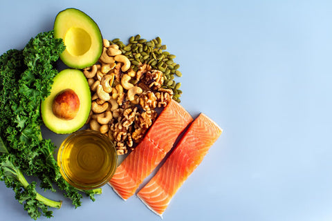 A selection of magnesium-rich food, including avocado, nuts, seeds, kale and olive oil