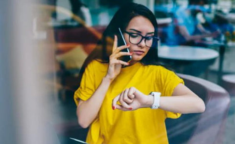 Lady in yellow t-shirt checking her fitness watch