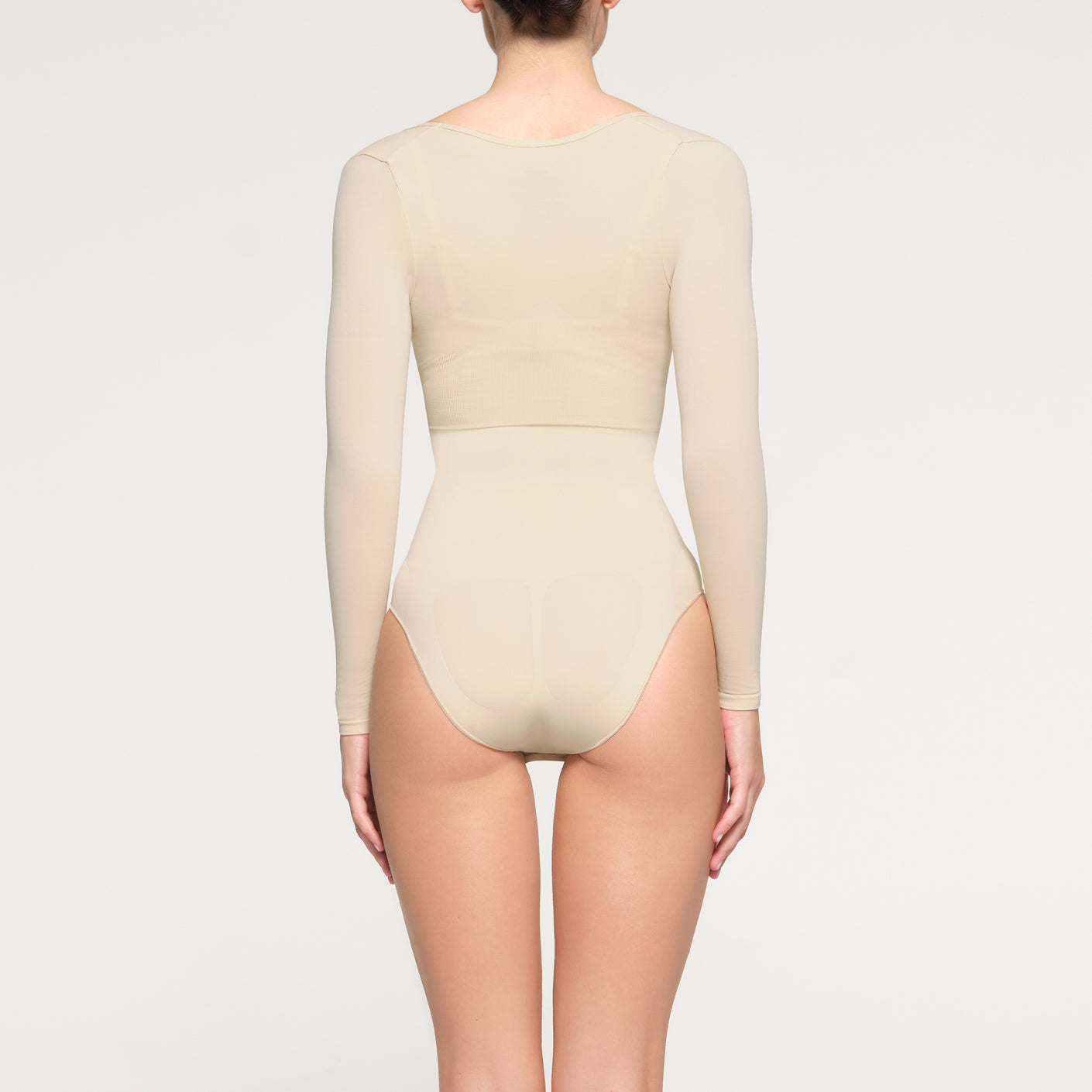 SEAMLESS SCULPT LONG SLEEVE OPEN BUST BRIEF BODYSUIT | SAND