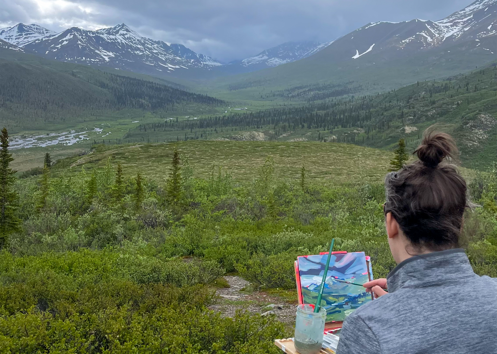 Amy Dixon painting a mountain range in Yukon.