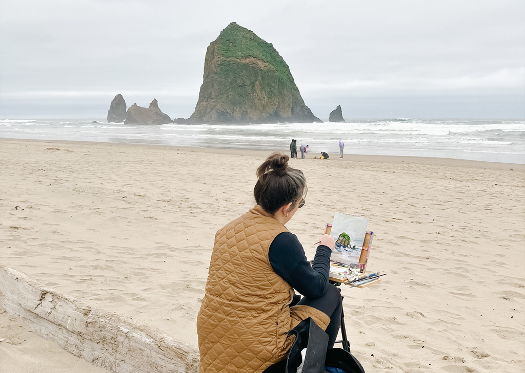 Amy Dixon painting the haystack at Cannon Beach in Oregon.