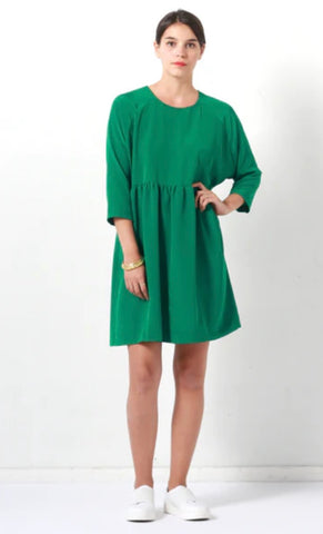 a lady wearing a green dress with raglan sleeves