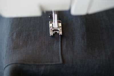 a close up of the pocket on the apron showing the marking of where to sew for the second time