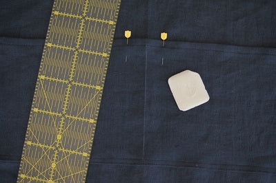 pocket with a ruler and chalk on the denim and a chalk mark down the centre to show the placement of the stitching