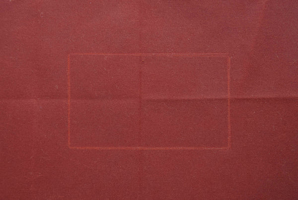 a dark red oilskin which has a white rectangle traced on it. 