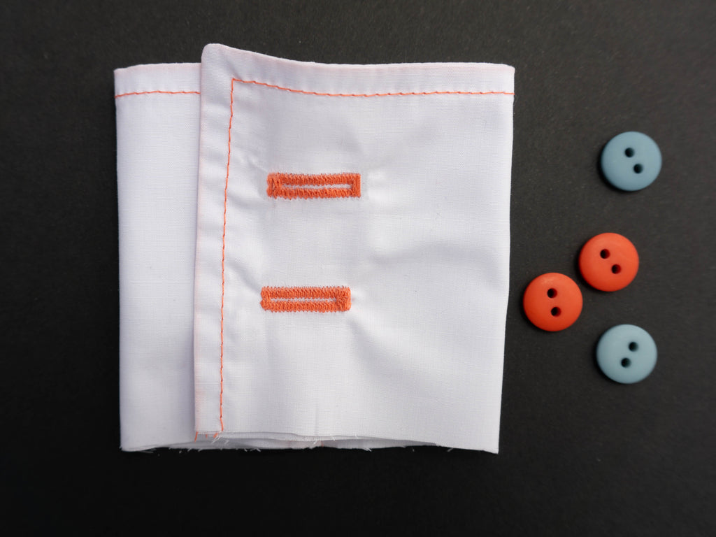 a picture of a white shirt cuff with orange and sage green buttons next to it