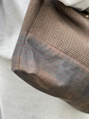 a close up of the side seam of the bag where the wool fabric meets the oilskin fabric. 
