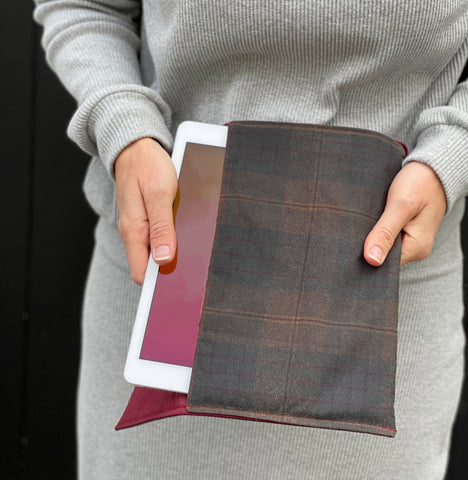 a white woman pulling an iPad out of the case. She is wearing grey clothing