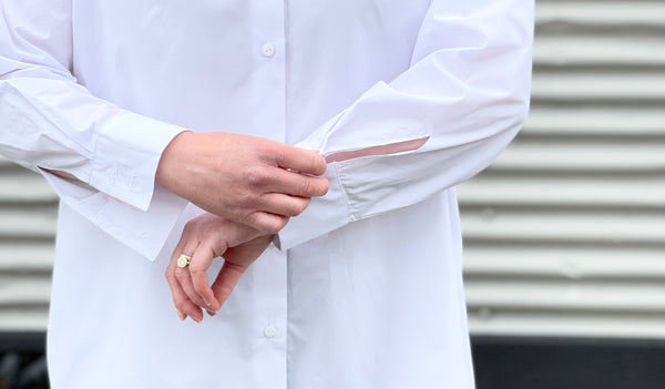 a close up of some cuffs with a pair of hands doing them up