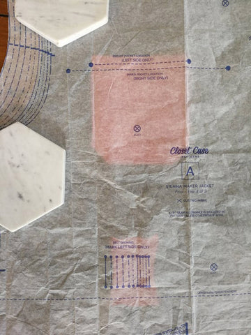 a photo of the paper dress making pattern laid over the top of the fabric. The maker was seeing if the pocket placement was correct and it was.