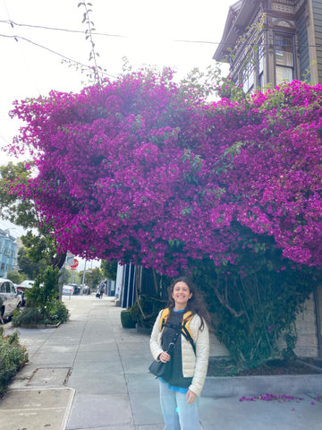 Emily standing in front of flowers.