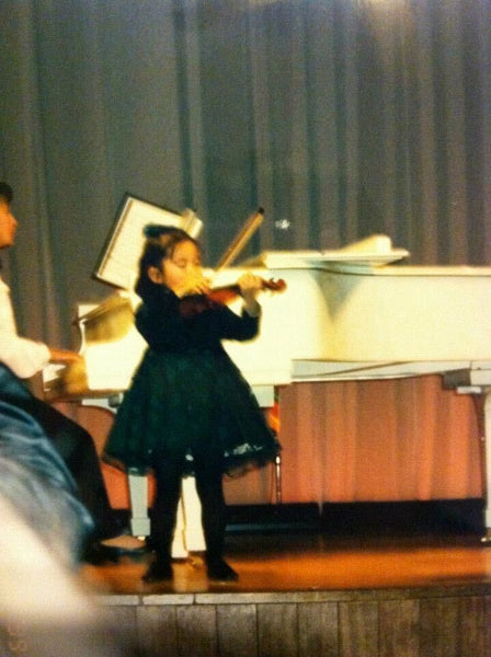 Lisa playing violin as a child.