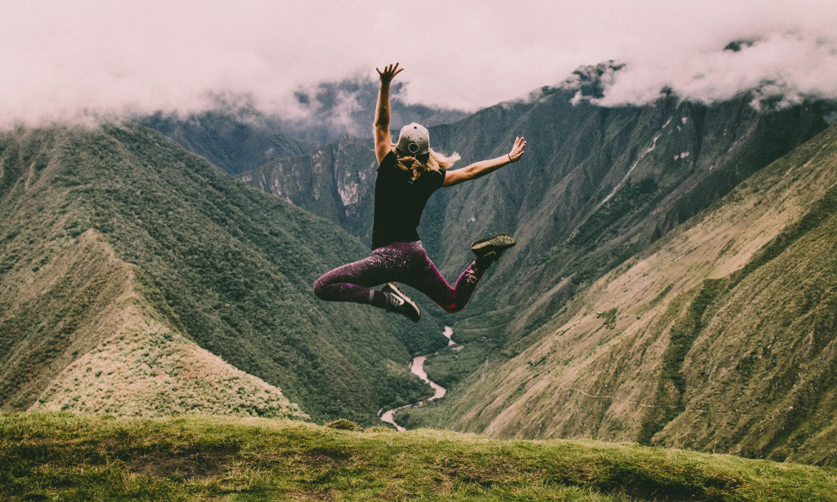 Person leaping joyfully in the mountains