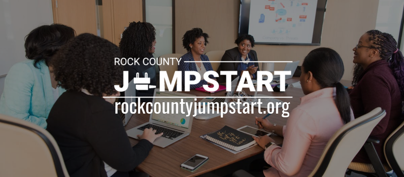 Seven people sitting around a conference table, with the Rock County Jumpstart logo overlaid.