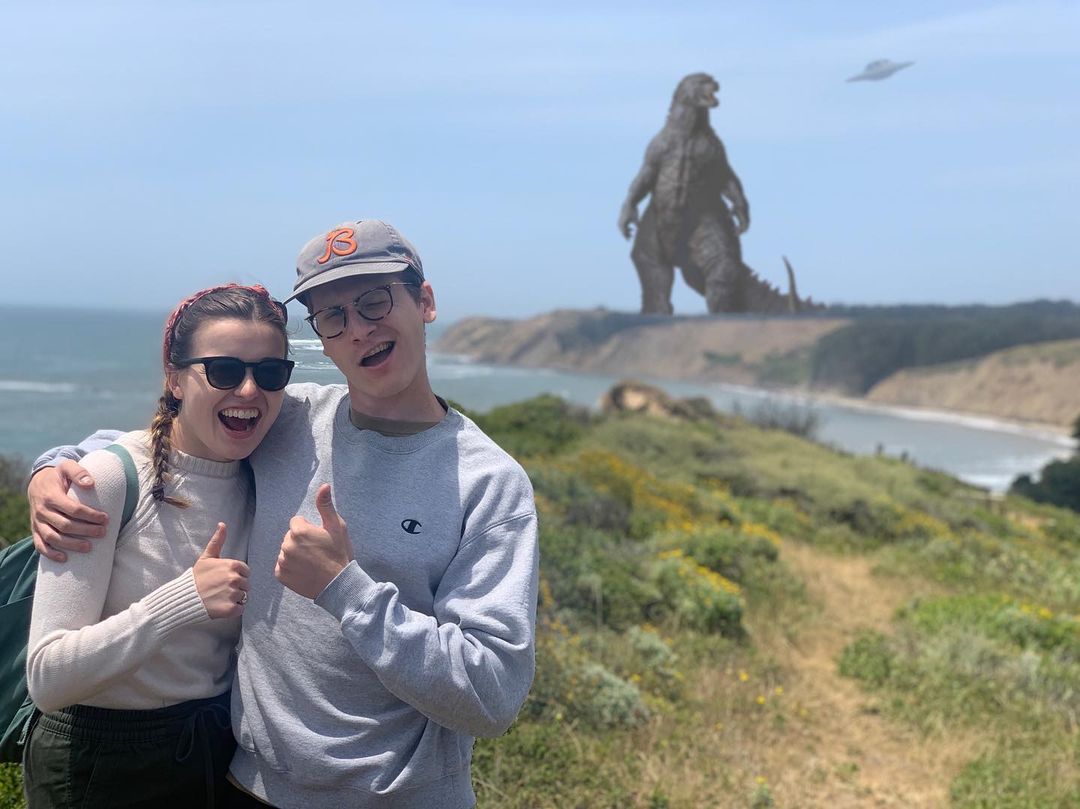 Neal posing with a Godzilla figure in the background.