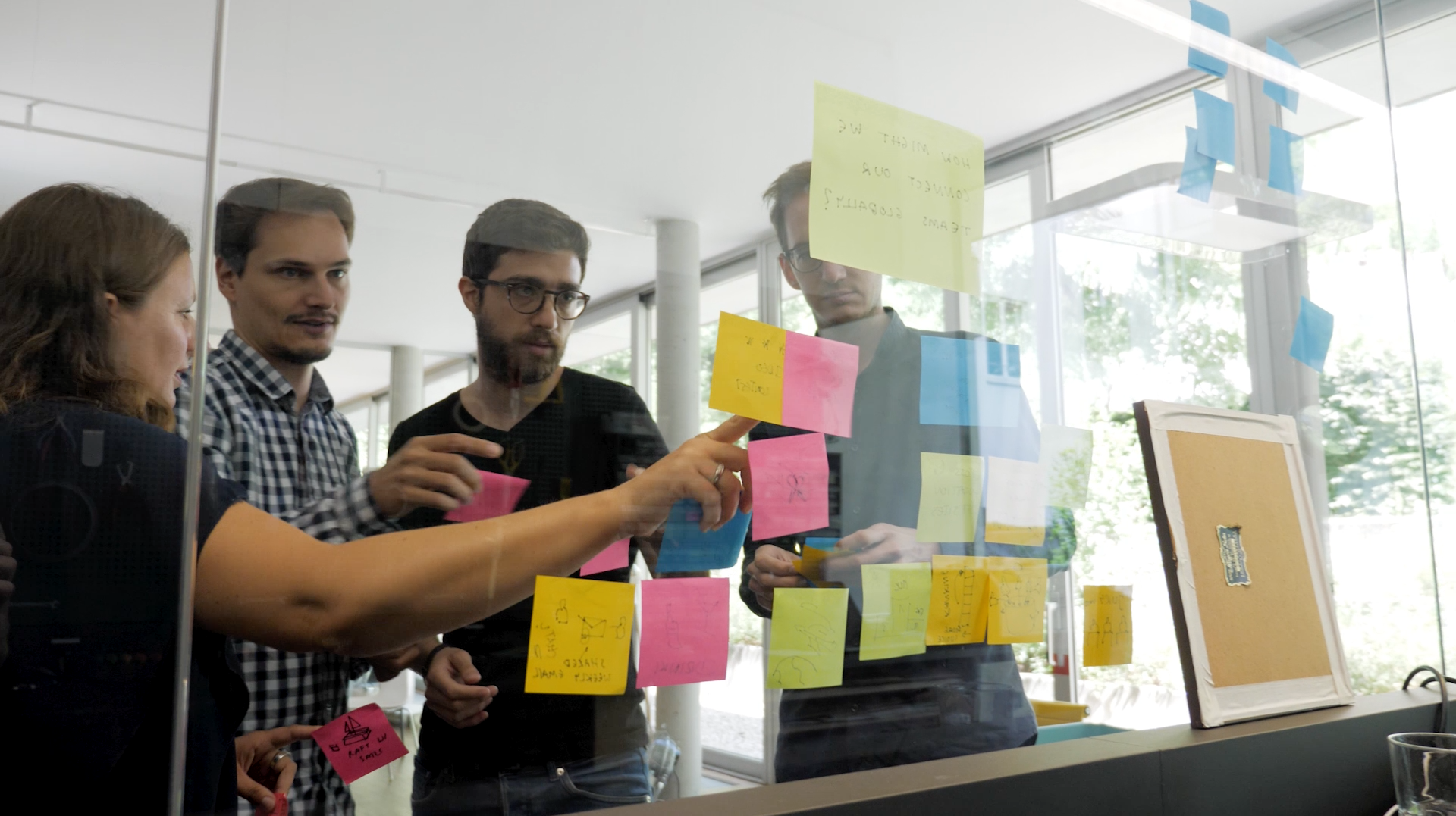 Four people collaborating with Post-its.