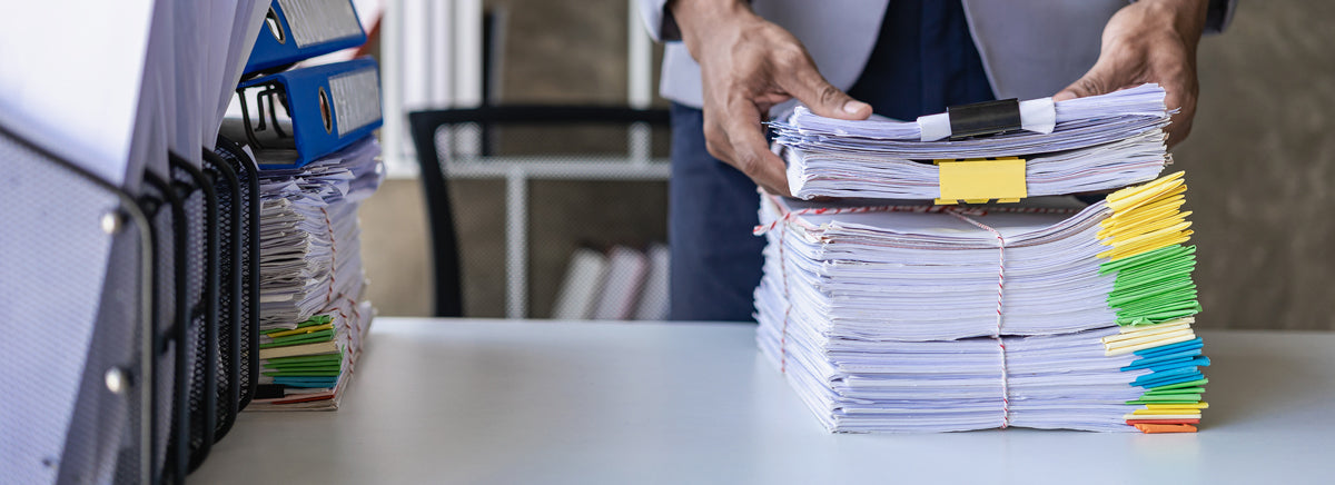 Stacks of paper documents on an office desk