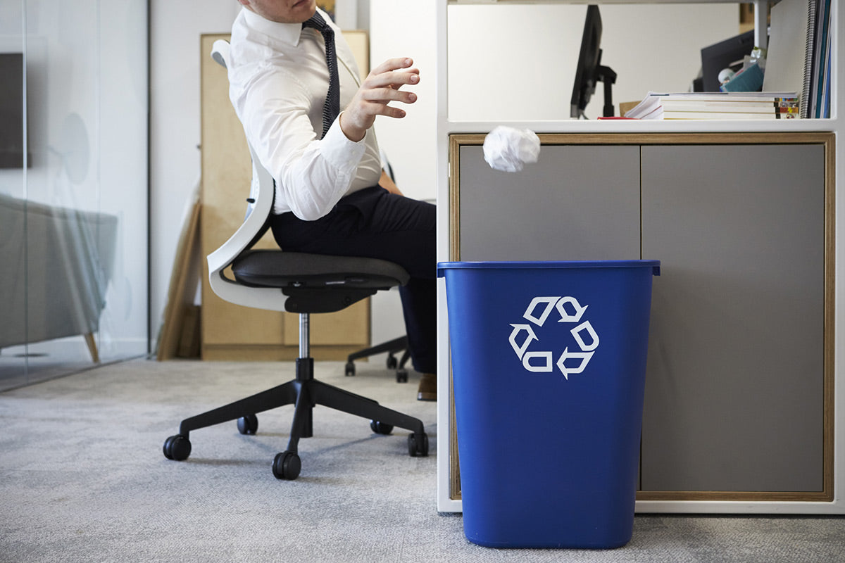 Man recycling paper while at work to promote office sustainability