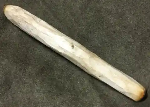 A carved stick with burn marks at the end.