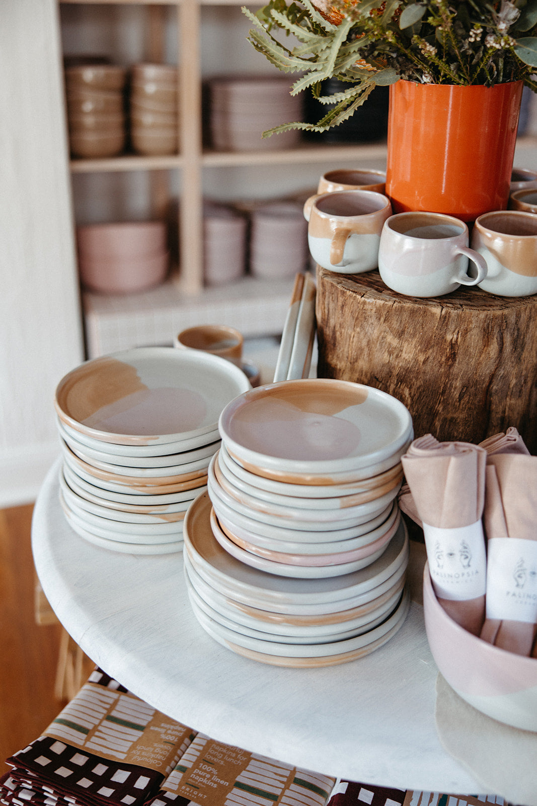 Stacks of colourful dinner sets in pink and chocolate brown by Palinopsia Ceramics on Darby Street