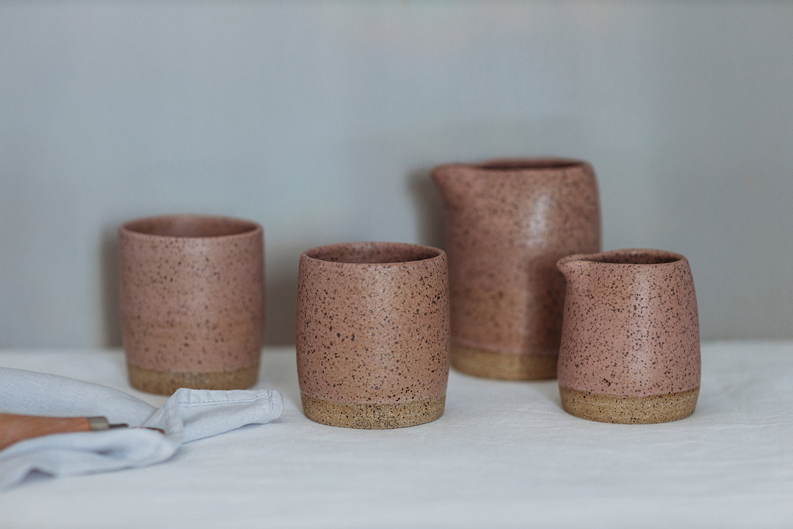 Australian handmade ceramics mugs, cups, jugs, hand pitcher and vases in speckled pink by potter Elkie for Palinopsia Ceramics in Newcastle NSW 