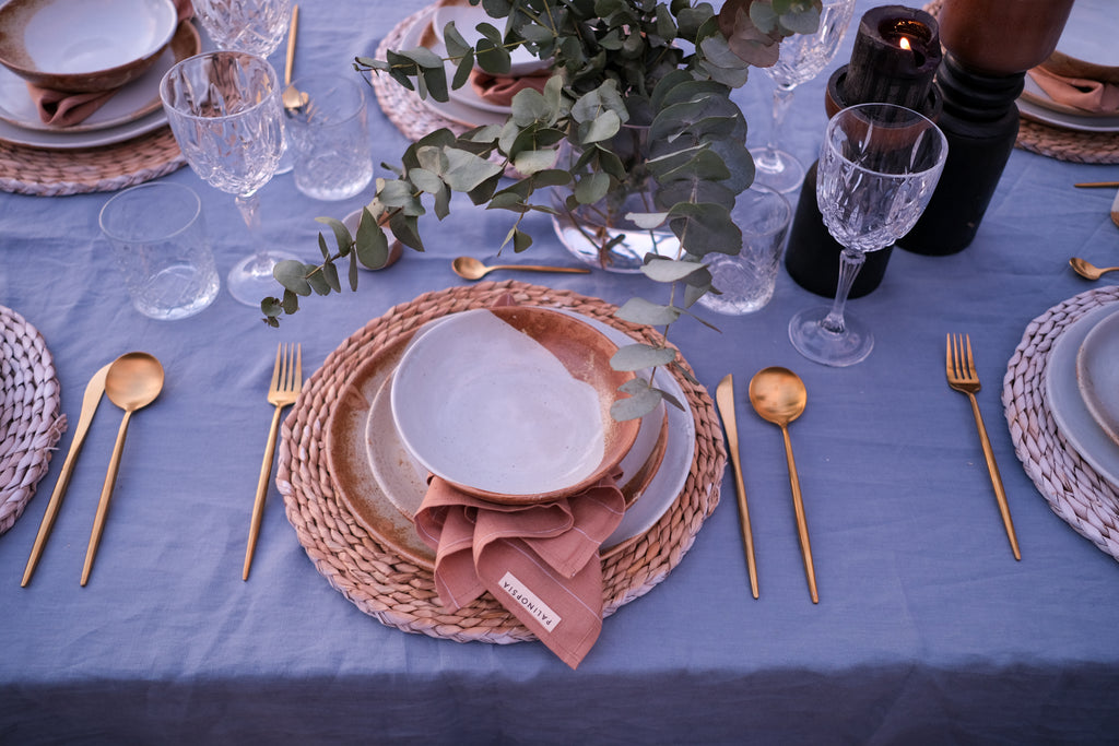 Full Dinnerware Set in rustic brown and blue colour, table set on a blue linen tablecloth with gold cutlery