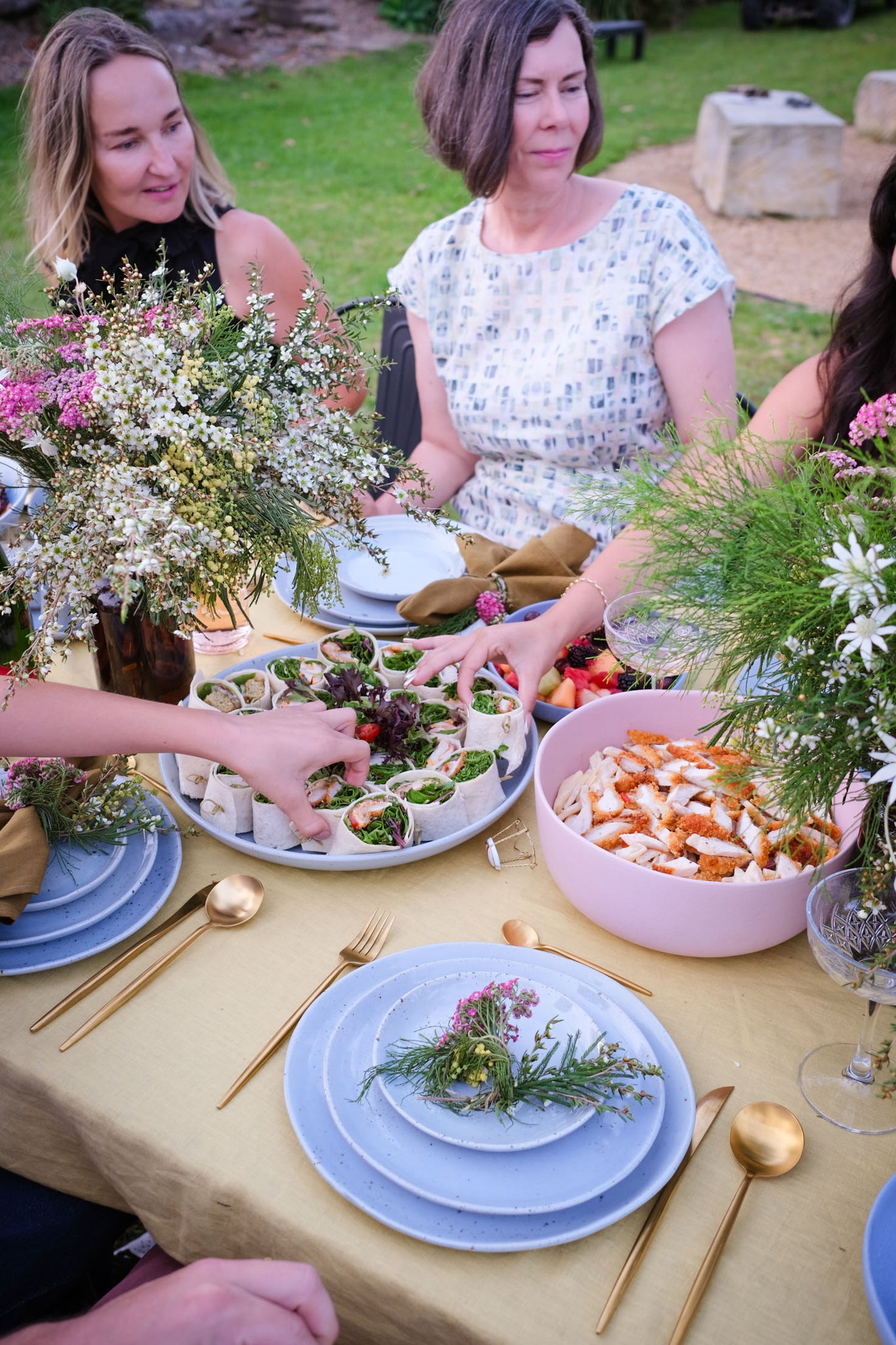 Women dining outdoors at a bright summer dining table by Palinopsia Ceramics and catered by Soul Origin in Sydney Australia