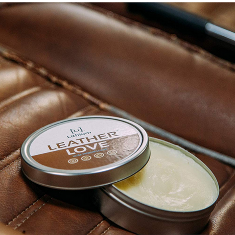 an open can of Leather Love conditioner on brown leather seats