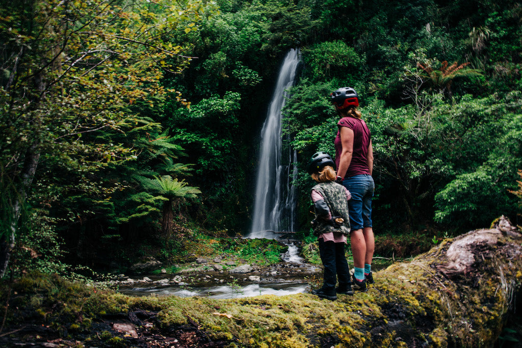 Mother and child looking at waterfall in bush