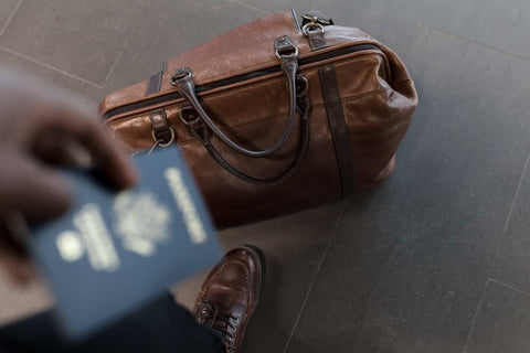 brown luggage with blue passport