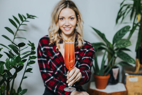 Cami holding low alcohol, low calorie, mindful cocktail. Wild Life Botanicals low alcohol sparkling wine.