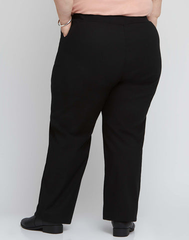 Back view of size 18 model wearing black stretch plus size work pants with an adjustable waist.