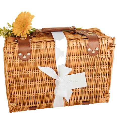 wicker picnic basket with a brown handle, white ribbon, gift tag and sunflower