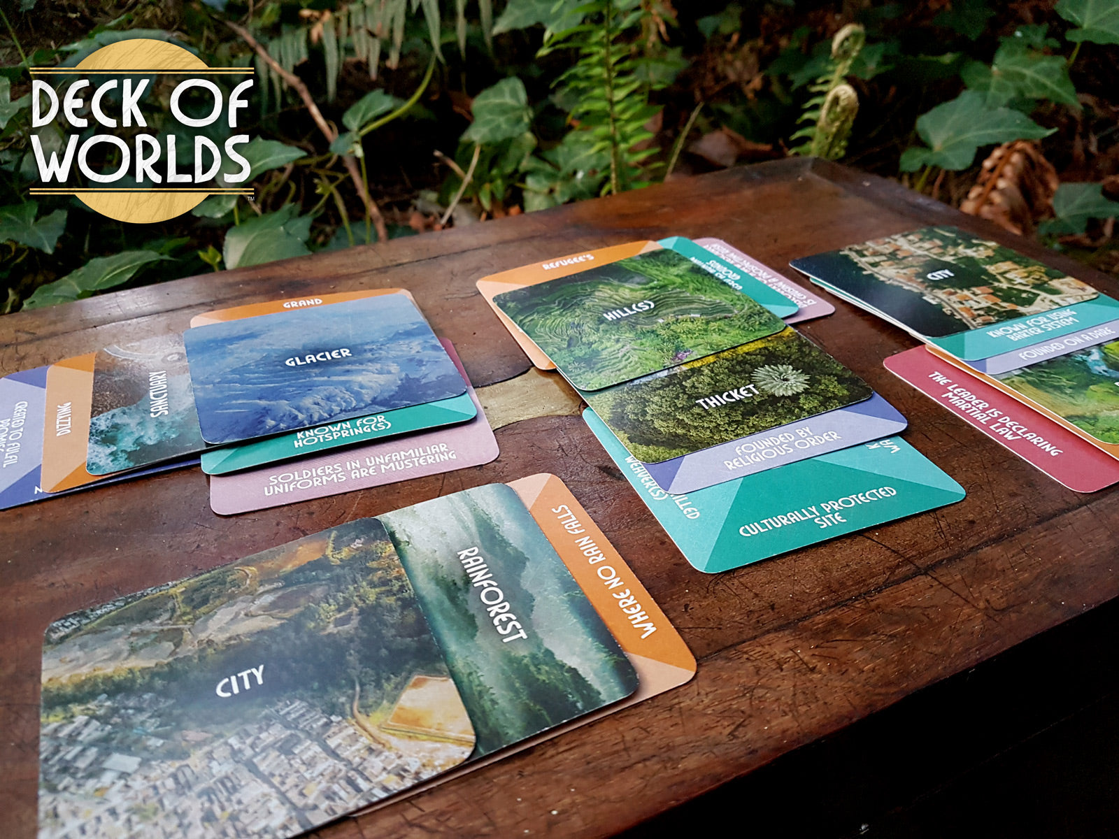 Photo of a map of Deck of Worlds cards laid out on a wooden box in a forest.