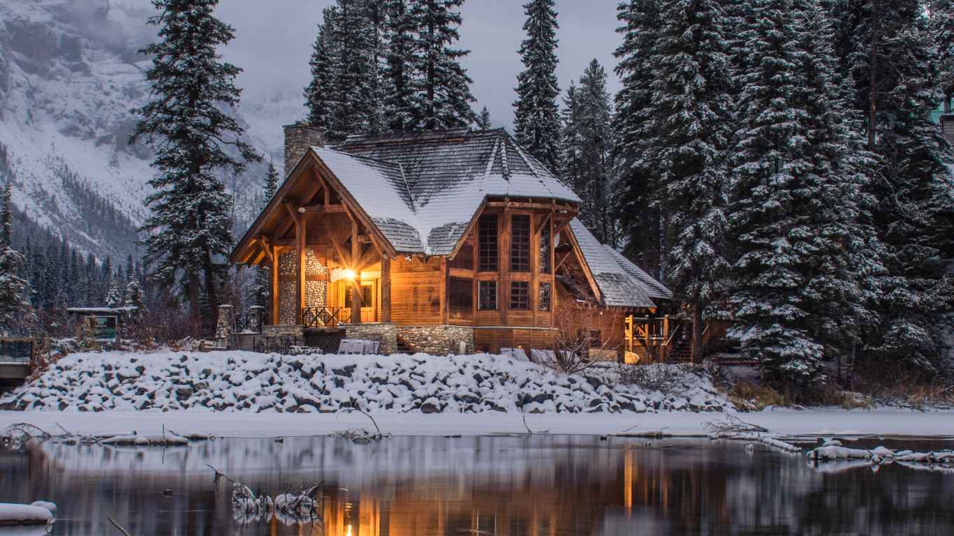 Photo of a snowy cabin beside a lake. Photo by Ian Keefe.