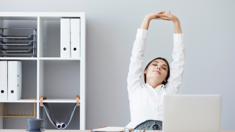 woman stretching in front of a desk