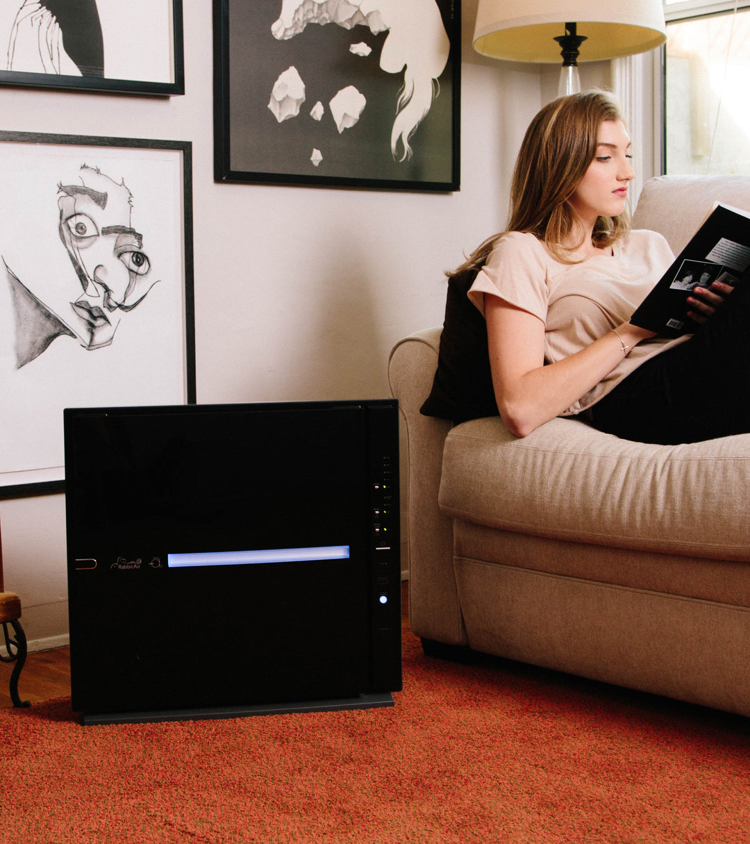 Black MinusA2 air purifier sitting by the couch