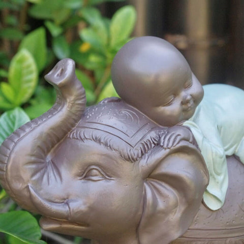Ceramic monk riding on an elephant