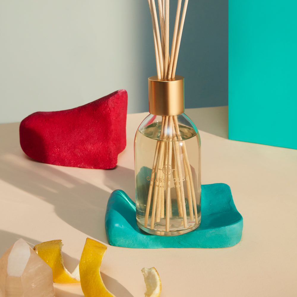scented glasshouse diffuser in a glass bottle with a golden cap