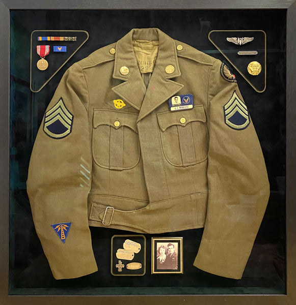 Shadowbox of military jacket from WWII containing military decorations, a photograph and ribbons.