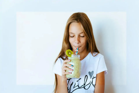 young girl drinking moringa smoothie