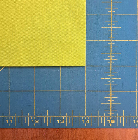 Close-up of fabric on a cutting mat that has been trimmed to 14 inches by width of fabric.