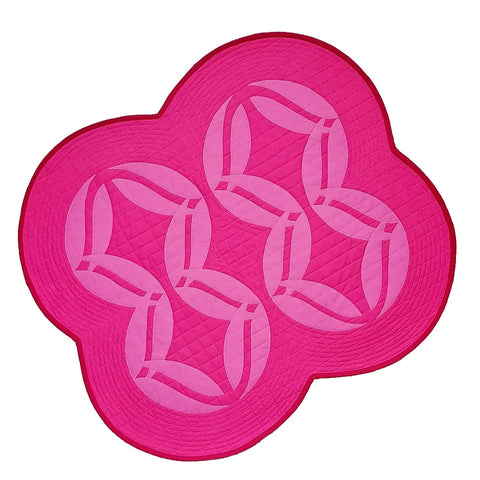 The PinkBomb 88 quilt is a pink quilted wall hanging with light pink appliqué petals attached in the shape of 88.