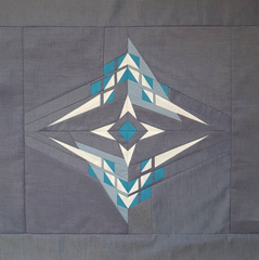 the square of pegasus quilt top with a grey blue background