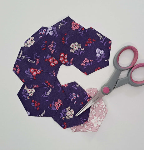 Seven hexagons cut from floral fabrics placed in a circle.