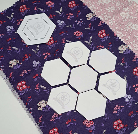 Hexagon templates cut out and placed on floral fabrics